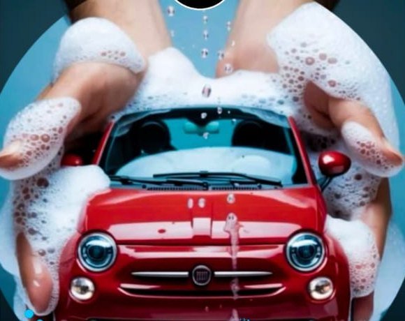 Two foam-covered hands cupped around a small red car, held like something fragile